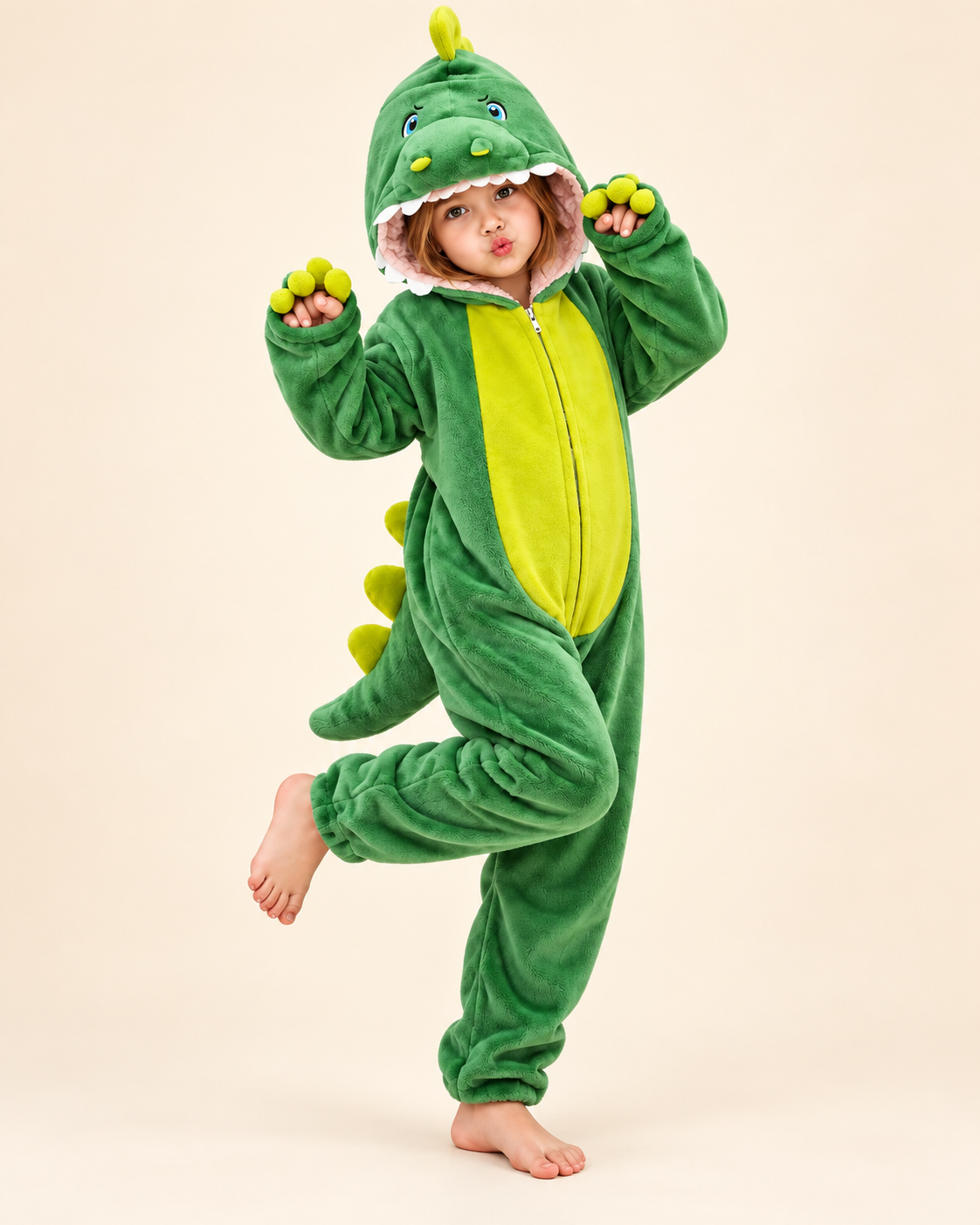 Child wearing a green dinosaur costume onesie