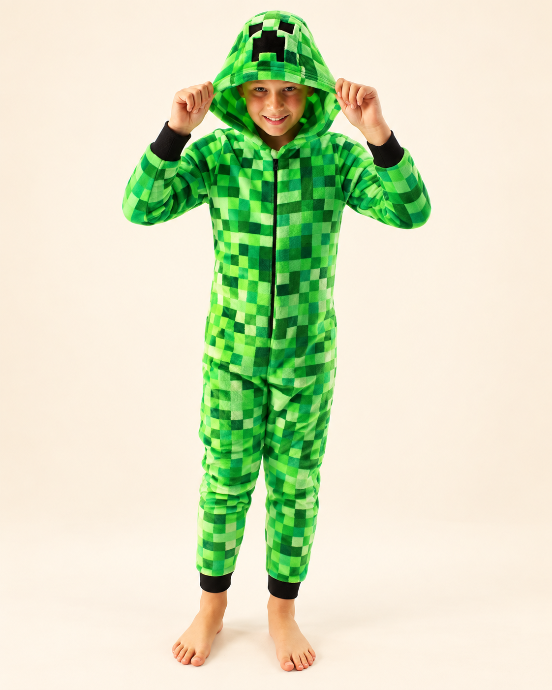 Child wearing a green pixel-pattern Creeper Halloween onesie