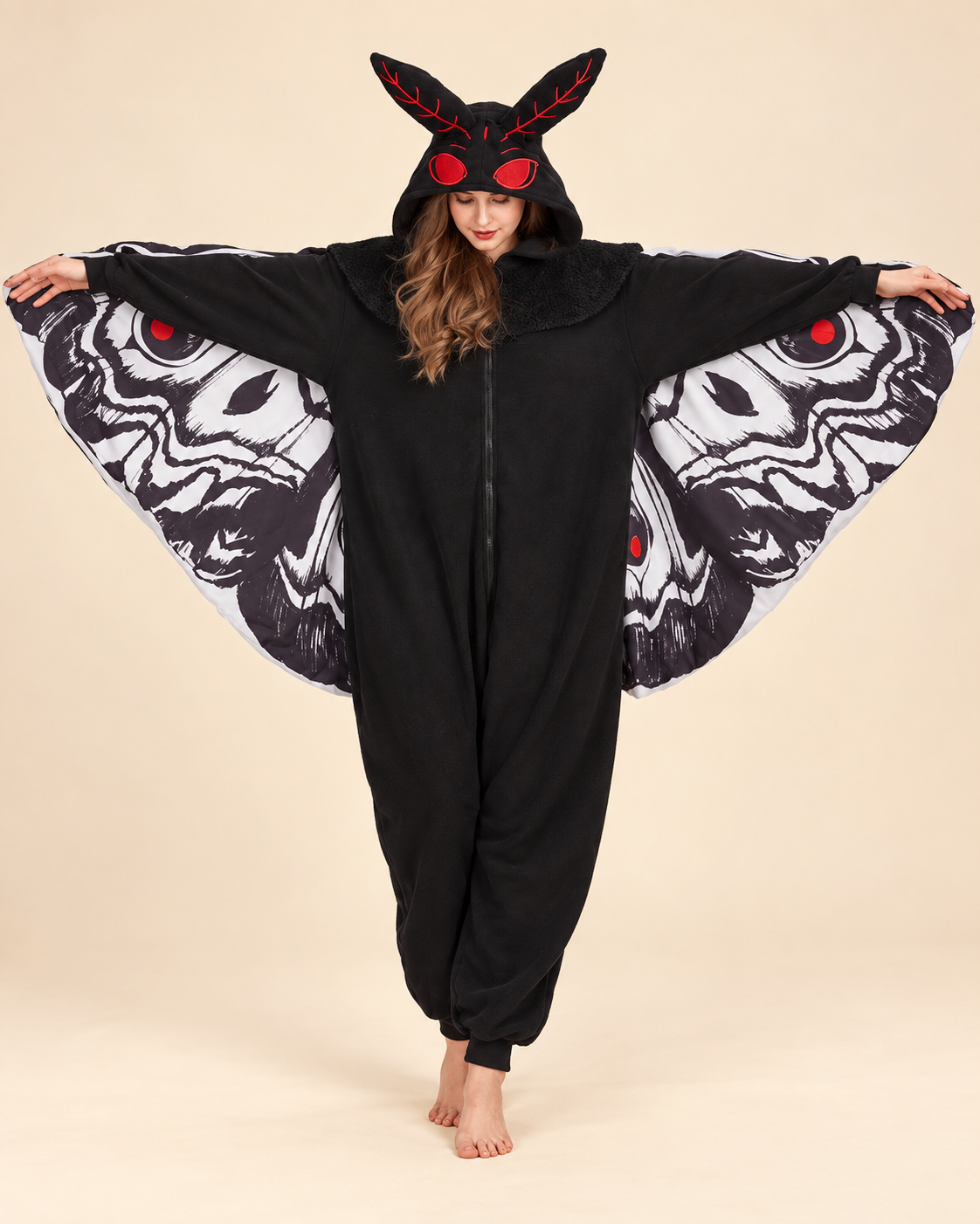 Adult wearing a black Mothman costume onesie with patterned wings