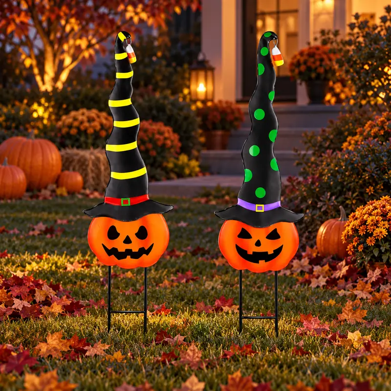 Two pumpkin faces with tall witch hats as garden stakes